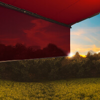 Ciel au coucher de soleil avec des teintes rouges et une forme d'ombrage sur le côté.