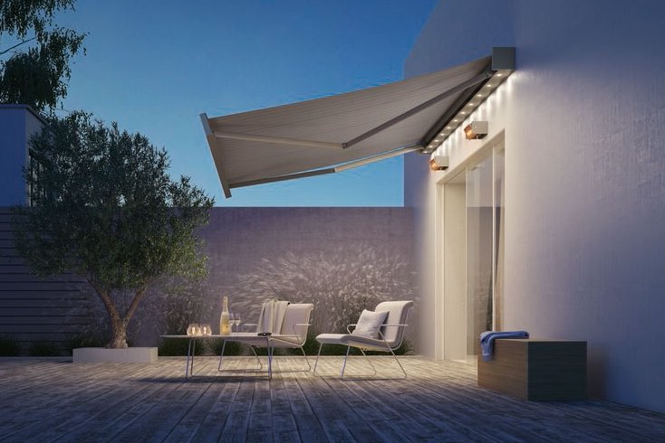 Sonnenmarkise in einem modernen Terrassensituation mit Holzfußboden und Bäumen im Hintergrund. Sonnenmarkise in einem modernen Terrassensituation mit Holzfußboden und Bäumen im Hintergrund.
