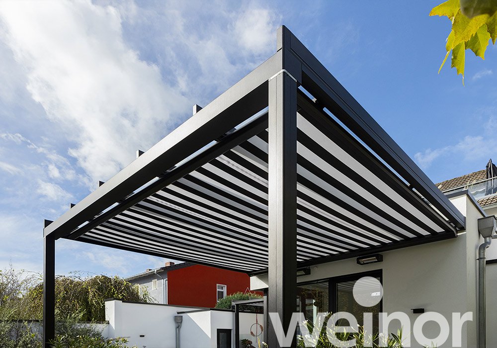 Überdachung mit horizontalen, gestreiften Markisentuch in Schwarz und Weiß, integriert in eine moderne Terrassensituation.