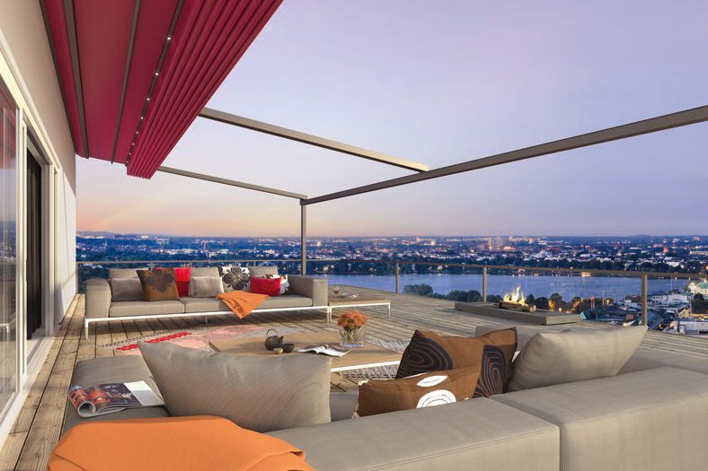 Vue d'une terrasse avec une surplomb rouge, des canapés modernes et un panorama sur la ville au crépuscule. Vue d'une terrasse avec une surplomb rouge, des canapés modernes et un panorama sur la ville au crépuscule.