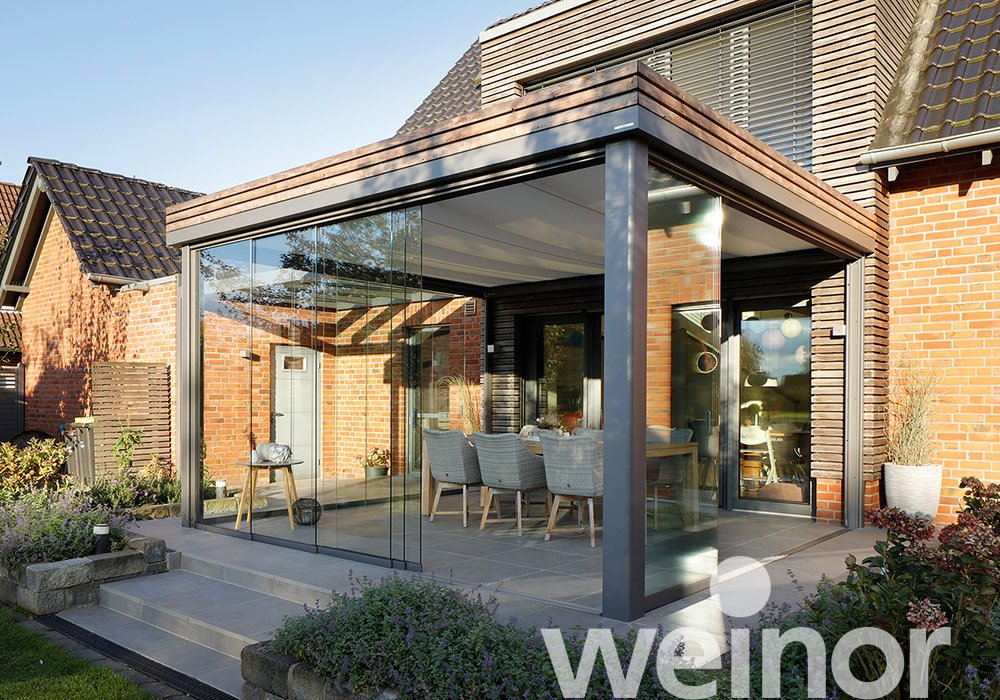 Wintergarten-Markise mit Glaswänden und einem modernen, klaren Design. Elegante Terrassensituation im Hintergrund.