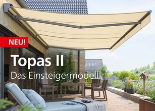 Markise in hellem Beige, montiert an einer Terrasse mit Pflanzen und Sitzgelegenheiten. 
