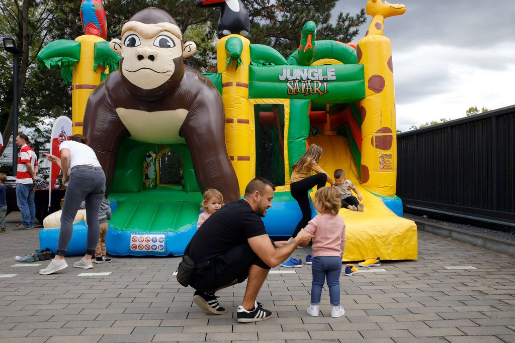 Kind auf einer Hüpfburg mit einem großen Affen und weiteren Spielgeräten im Hintergrund. Kind auf einer Hüpfburg mit einem großen Affen und weiteren Spielgeräten im Hintergrund.