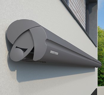 caisson de store au design rond et couleur gris, installé sur un mur extérieur.