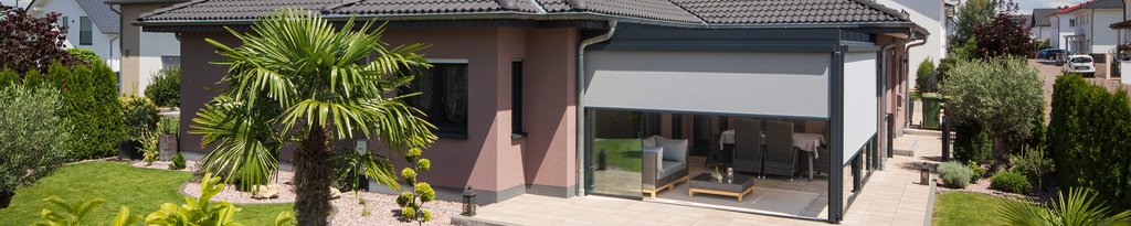 Een moderne woning met een overdekte terrasruimte en groene tuin. Een moderne woning met een overdekte terrasruimte en groene tuin.