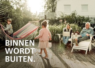 Familie entspannt im Freien, während Kinder spielen. Sonnenlicht durch leuchtendes Grün und Holzboden. 
