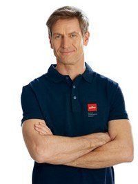 Mann mit verschränkten Armen in dunkelblauer Poloshirt, freundlicher Gesichtsausdruck. Mann mit verschränkten Armen in dunkelblauer Poloshirt, freundlicher Gesichtsausdruck.