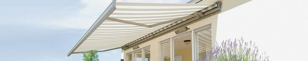 Marquise rayée en tissu blanc et beige, installée au-dessus d'une terrasse.