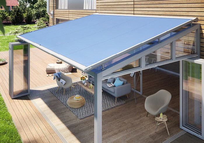 Markise in blau über einer Terrassensituation mit Glas-Schiebewänden und modernem Design. Markise in blau über einer Terrassensituation mit Glas-Schiebewänden und modernem Design.