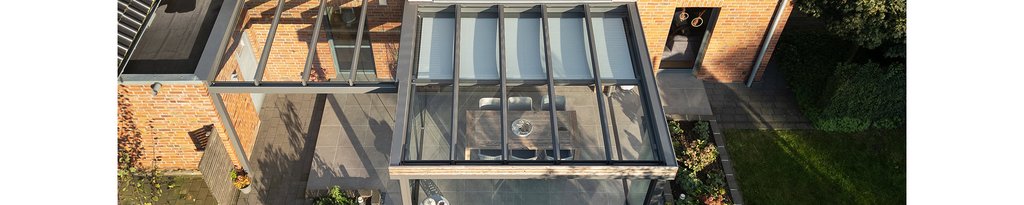 Glasüberdachung über einer Terrassensituation mit moderner Architektur und Holzverkleidung. Glasüberdachung über einer Terrassensituation mit moderner Architektur und Holzverkleidung.