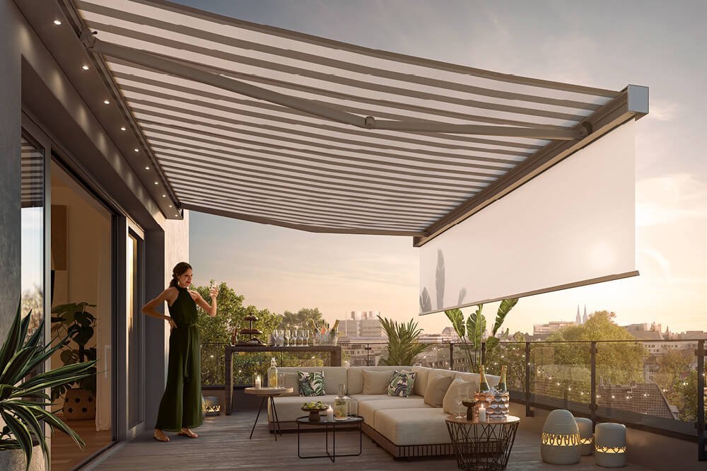 Eine großzügige Markise mit gestreiftem Design über einer modernen Terrassensituation im Abendlicht. Eine großzügige Markise mit gestreiftem Design über einer modernen Terrassensituation im Abendlicht.