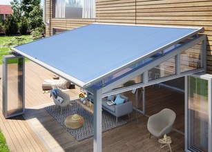 Markise in modernem, rundem Design über einer Terrassensituation mit Holzdeck und Glas-Schiebewänden. 